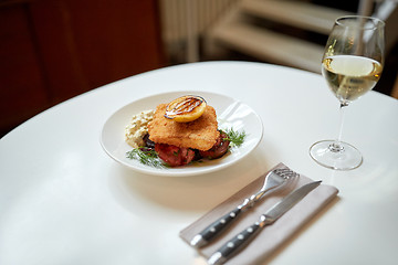 Image showing fish salad and wine glass on restaurant table 