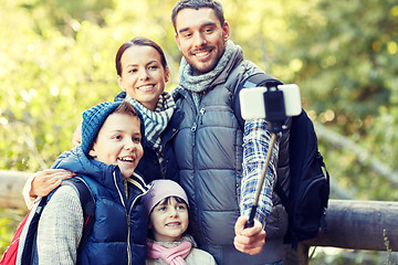 Image showing happy family with smartphone selfie stick in woods