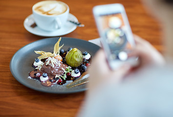 Image showing woman with smartphone photographing food at cafe