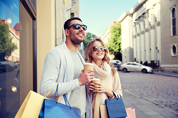 Image showing happy couple with shopping bags and coffee in city