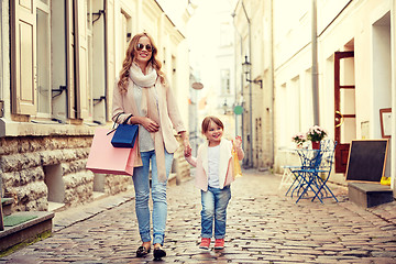 Image showing happy mother and child with shopping bags in city