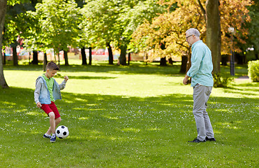 Image showing old man and boy playing football at summer park