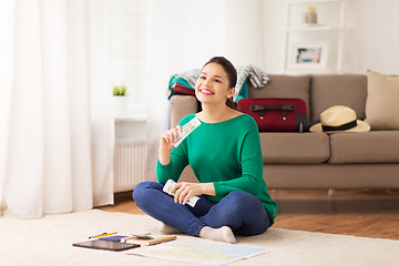 Image showing happy woman with money and travel map at home