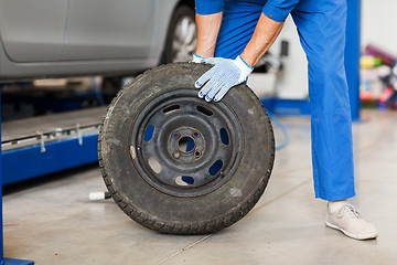 Image showing mechanic with wheel tire at car workshop