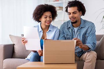 Image showing happy couple with parcel box and paper form home