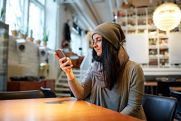 Image showing young woman with smartphone at cafe