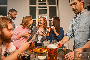 Image showing Group of friends enjoying evening drinks with beer