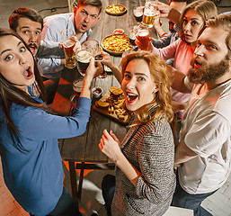 Image showing Group of friends enjoying evening drinks with beer