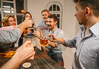 Image showing Group of friends enjoying evening drinks with beer