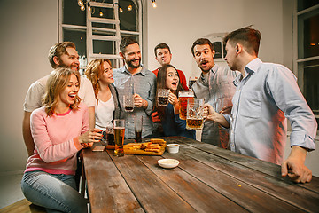 Image showing Group of friends enjoying evening drinks with beer