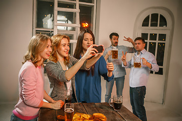 Image showing Group of friends enjoying evening drinks with beer