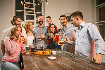 Image showing Group of friends enjoying evening drinks with beer