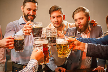 Image showing Group of friends enjoying evening drinks with beer