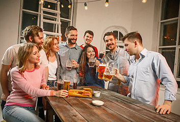 Image showing Group of friends enjoying evening drinks with beer