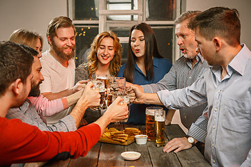 Image showing Group of friends enjoying evening drinks with beer