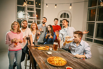 Image showing Group of friends enjoying evening drinks with beer