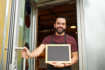 Image showing man or waiter with blackboard at bar entrance door