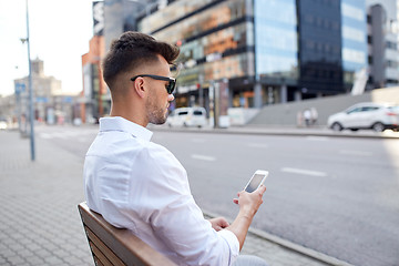 Image showing close up of man texting on smartphone in city