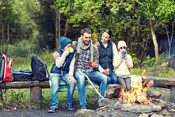 Image showing happy family sitting on bench at camp fire