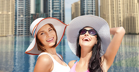 Image showing happy young women in hats on summer beach