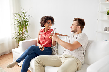 Image showing happy friends or couple with beer talking at home