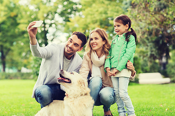 Image showing happy family with dog taking selfie by smartphone