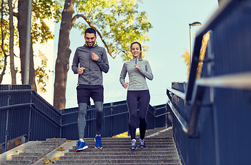 Image showing happy couple running downstairs in city