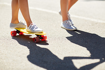 Image showing feet of teenage couple riding skateboard on road