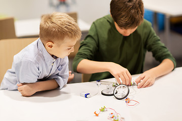 Image showing happy children building robots at robotics school