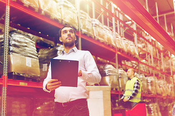 Image showing businessman with clipboard at warehouse