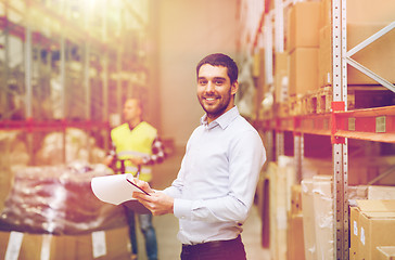 Image showing happy businessman with clipboard at warehouse