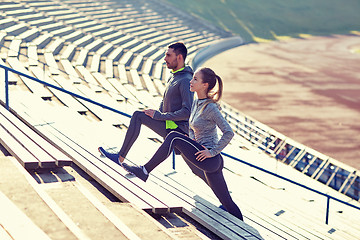 Image showing couple stretching leg on stands of stadium