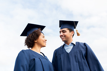 Image showing happy students or bachelors in mortarboards