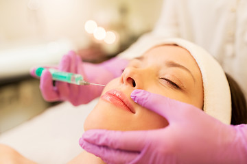 Image showing beautician doing beauty injection to woman lips