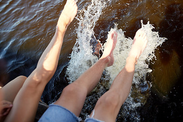Image showing legs of couple splashing water in river
