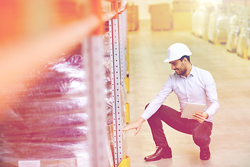 Image showing happy businessman with tablet pc at warehouse