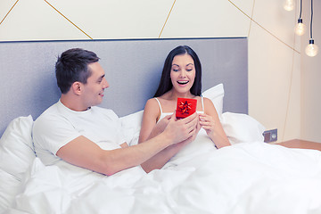 Image showing man giving woman little red gift box