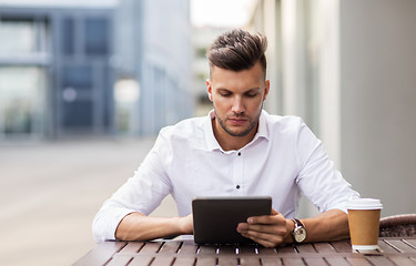 Image showing man with tablet pc and coffee at city cafe