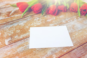 Image showing close up of red tulips and blank paper or letter