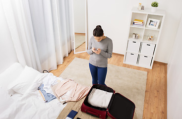 Image showing woman packing travel bag at home or hotel room