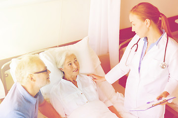 Image showing senior woman and doctor with clipboard at hospital