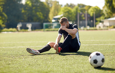 Image showing injured soccer player with ball on football field