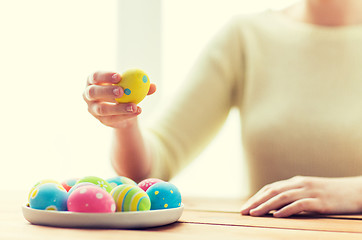 Image showing close up of woman hands with colored easter eggs