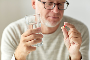 Image showing close up of hands with medicine pills and water