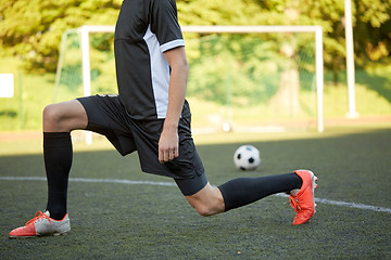 Image showing soccer player stretching leg on field football