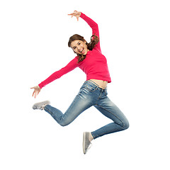 Image showing happy young woman jumping in air or dancing