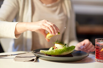 Image showing woman eating caviar salad at cafe or restaurant