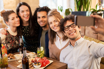 Image showing friends taking selfie by smartphone at bar or cafe