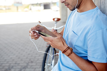 Image showing man with earphones and smartphone listening music