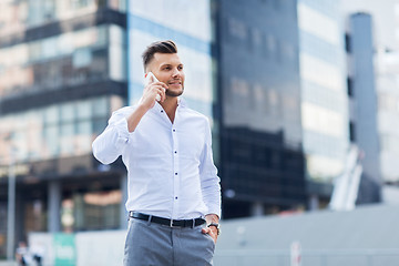 Image showing happy man with smartphone calling on city street